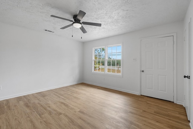 spare room featuring ceiling fan, a textured ceiling, and light wood-type flooring