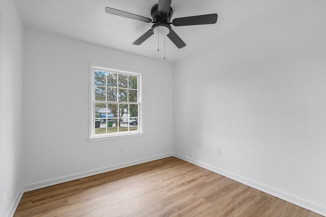 spare room with ceiling fan, a textured ceiling, and light wood-type flooring