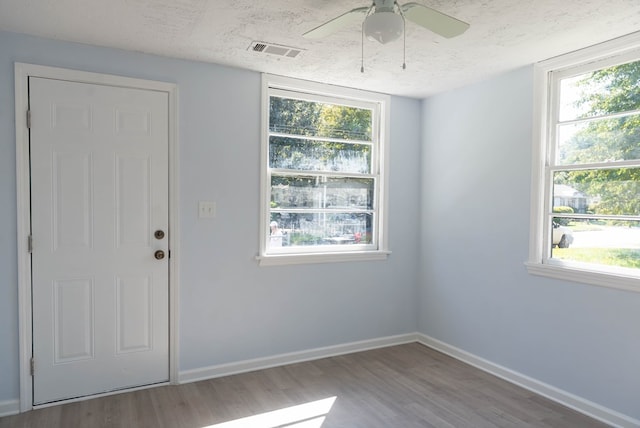 interior space featuring ceiling fan, light hardwood / wood-style floors, and a textured ceiling