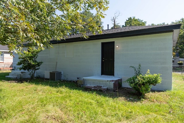 back of house with a yard and central AC unit