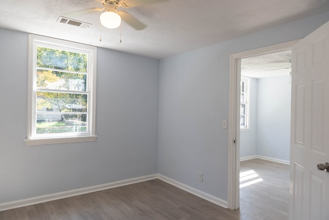 empty room with ceiling fan, hardwood / wood-style floors, and a textured ceiling