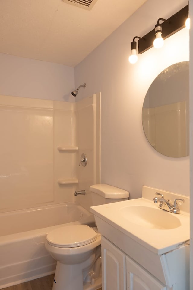 full bathroom featuring hardwood / wood-style floors, vanity, toilet, and tub / shower combination