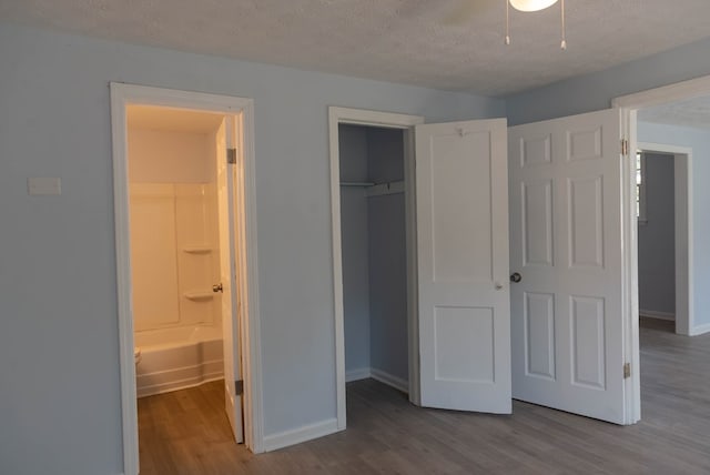 unfurnished bedroom with ensuite bath, light hardwood / wood-style flooring, and a textured ceiling