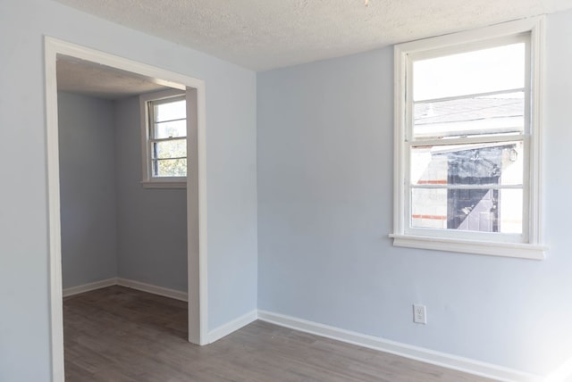 unfurnished room featuring hardwood / wood-style flooring and a textured ceiling