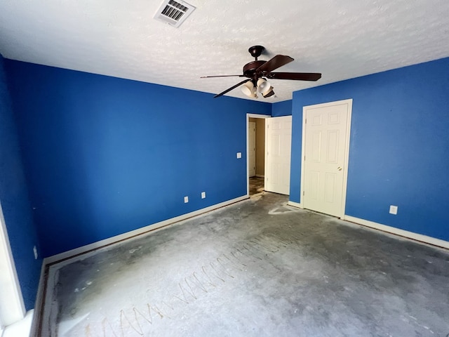 unfurnished bedroom with ceiling fan and a textured ceiling