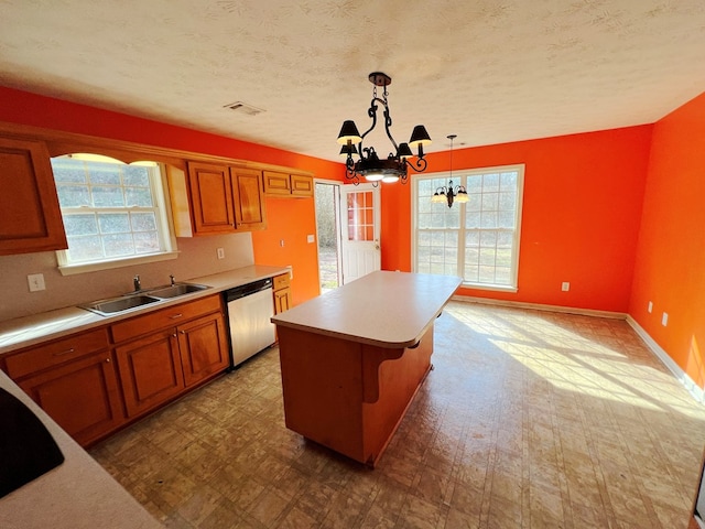 kitchen featuring a kitchen island, dishwasher, sink, hanging light fixtures, and a notable chandelier