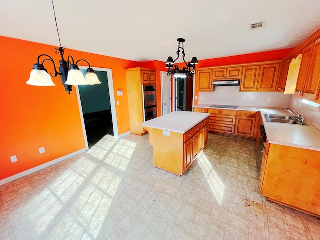 kitchen with pendant lighting, black electric stovetop, a chandelier, and a kitchen island