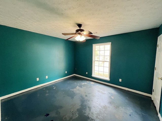 empty room featuring ceiling fan, concrete floors, and a textured ceiling