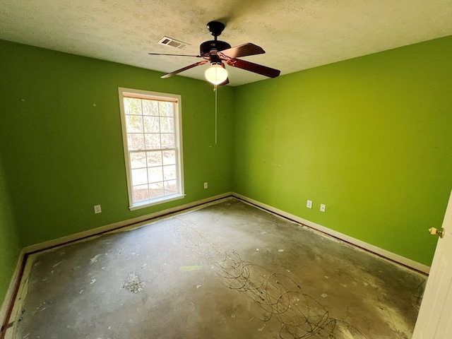 spare room featuring ceiling fan, concrete flooring, and a textured ceiling