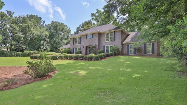 colonial-style house with brick siding and a front lawn