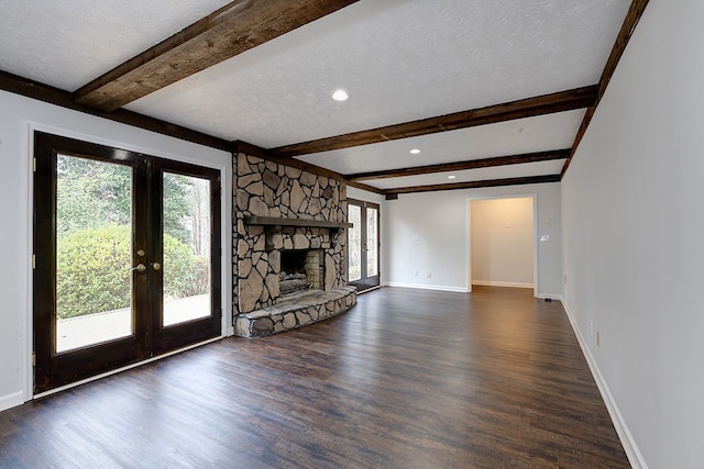 unfurnished living room with baseboards, beam ceiling, a textured ceiling, and dark wood-style flooring