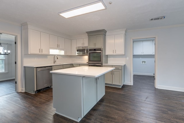 kitchen with visible vents, a kitchen island, light countertops, stainless steel appliances, and a sink