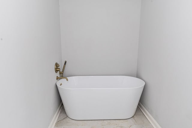 bathroom with baseboards and a freestanding bath