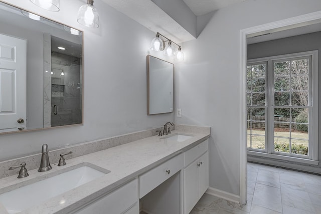 full bathroom featuring a marble finish shower, marble finish floor, double vanity, and a sink