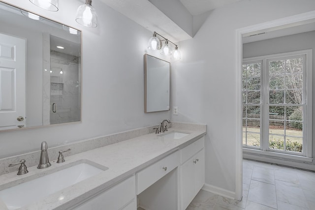 bathroom featuring a sink, a marble finish shower, marble finish floor, and double vanity