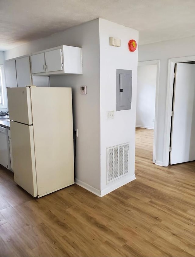 kitchen with white cabinetry, white appliances, electric panel, and light hardwood / wood-style floors