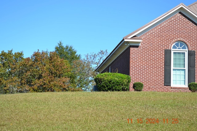 view of side of home with a yard