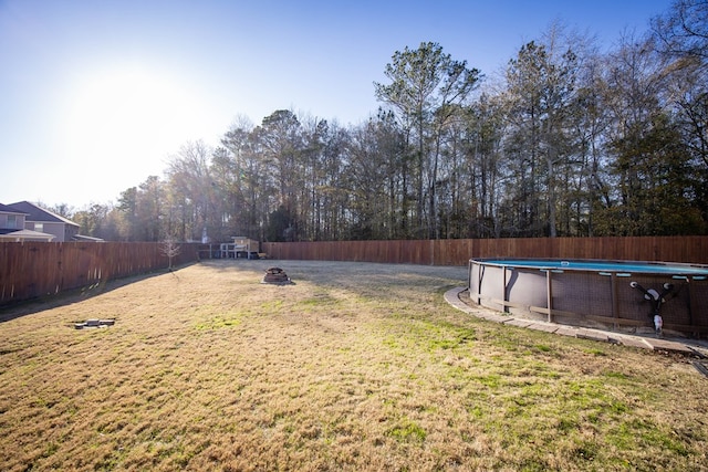 view of yard featuring a fenced in pool and a fire pit