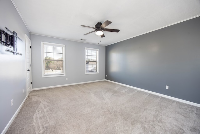 empty room with ornamental molding, light carpet, and ceiling fan