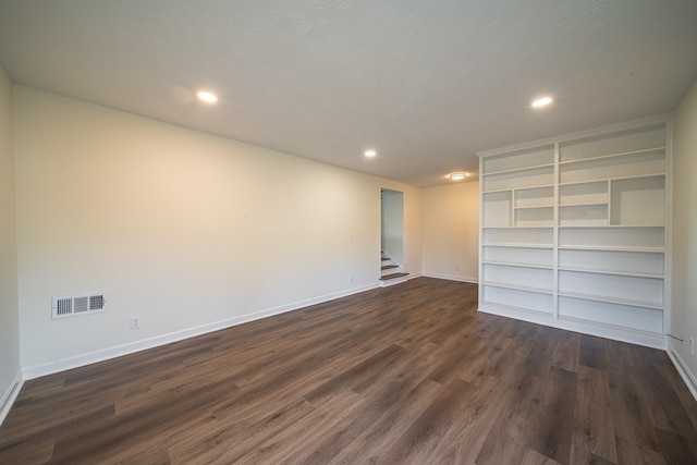 unfurnished room with a textured ceiling and dark hardwood / wood-style flooring