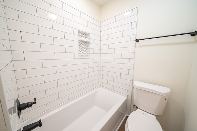 bathroom with tiled shower / bath combo and toilet