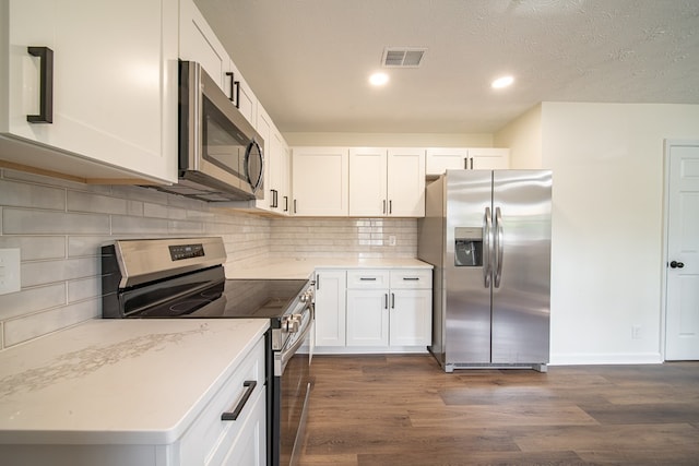 kitchen with dark hardwood / wood-style floors, a textured ceiling, light stone counters, white cabinetry, and stainless steel appliances