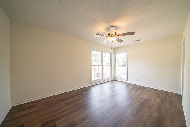 spare room featuring dark hardwood / wood-style floors, ceiling fan, and a textured ceiling