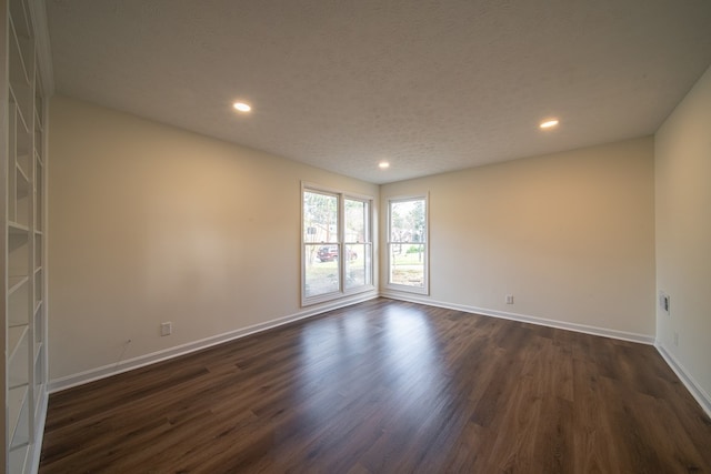 unfurnished room with a textured ceiling and dark hardwood / wood-style flooring