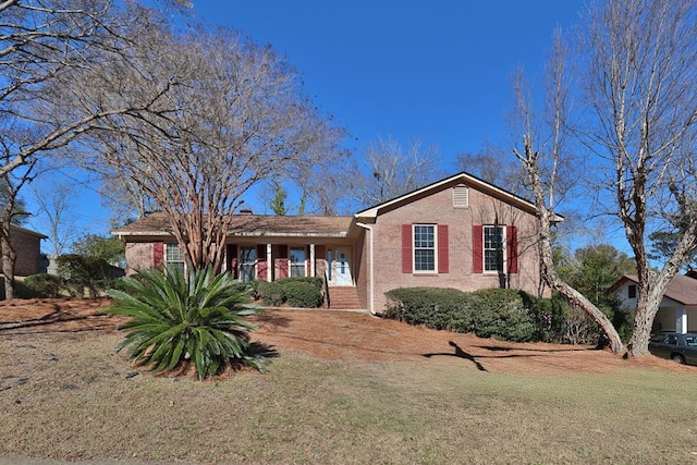 ranch-style house with a front yard and brick siding