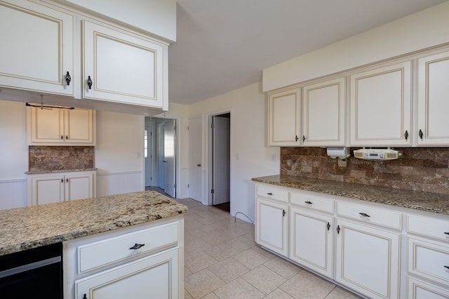 kitchen featuring light tile patterned floors, tasteful backsplash, and light stone counters