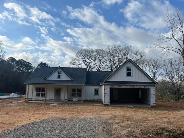 204 Lee Rd Unit 0334, Salem, AL 36874 - view of front of house with board and batten siding, dirt driveway, covered porch, a garage, and a shingled roof