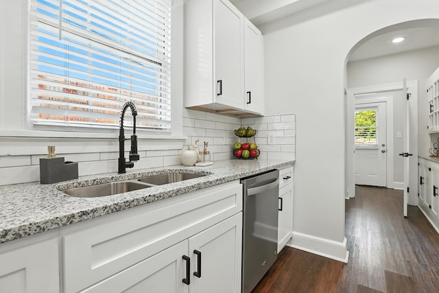 2901 Peabody Ave, Columbus, GA 31904 - kitchen with arched walkways, tasteful backsplash, dark wood-type flooring, stainless steel dishwasher, and light stone counters
