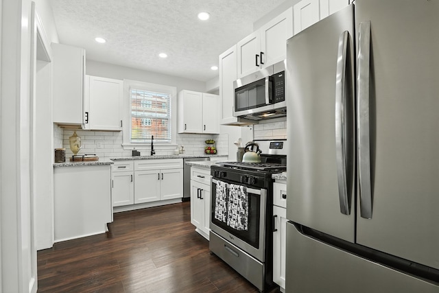 2901 Peabody Ave, Columbus, GA 31904 - kitchen with stainless steel appliances, backsplash, a textured ceiling, light stone counters, and white cabinets
