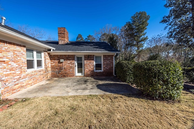 rear view of property with a yard and a patio