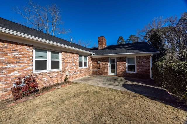 back of property with a patio area and a lawn