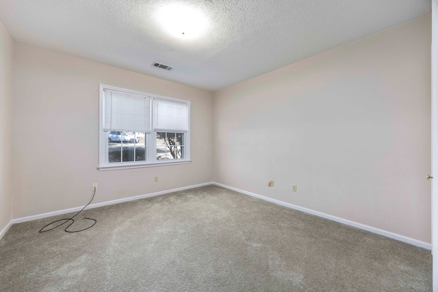 unfurnished room with carpet flooring and a textured ceiling