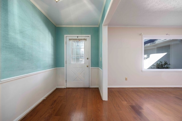 foyer with hardwood / wood-style flooring, ornamental molding, and a textured ceiling