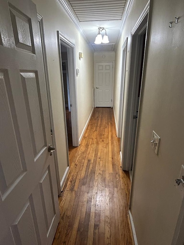 corridor featuring hardwood / wood-style flooring and ornamental molding