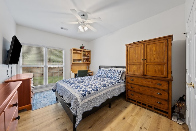 bedroom featuring a ceiling fan, visible vents, and light wood-style floors