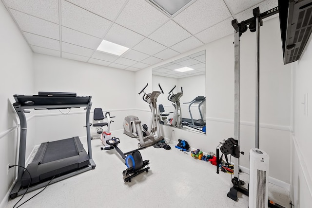 exercise room featuring baseboards and a drop ceiling