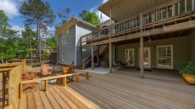 wooden deck featuring stairs, outdoor dining area, central AC, and a patio