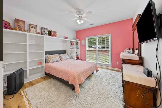 bedroom featuring a ceiling fan, wood finished floors, and visible vents