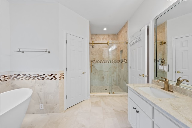 bathroom with vanity, wainscoting, recessed lighting, a freestanding bath, and a stall shower