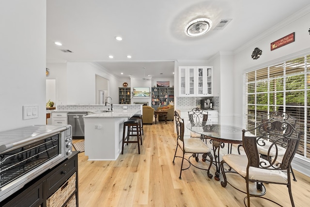 dining room featuring crown molding, visible vents, and a healthy amount of sunlight