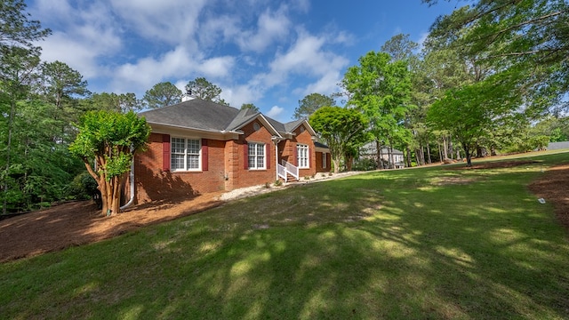 exterior space featuring a yard and brick siding