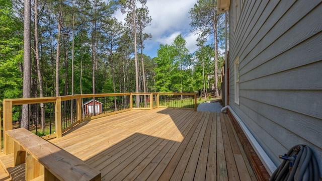 wooden deck featuring an outbuilding and a storage unit