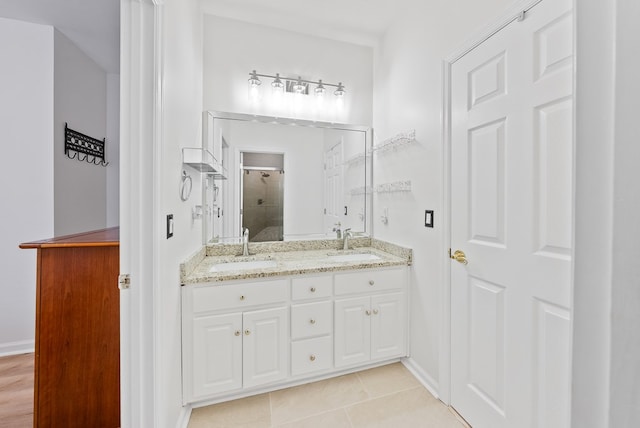 full bath featuring double vanity, a shower stall, a sink, and tile patterned flooring