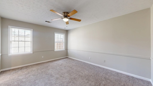 carpeted empty room with ceiling fan and a textured ceiling