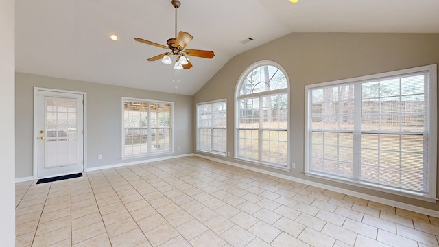 empty room featuring lofted ceiling, light tile patterned floors, and ceiling fan