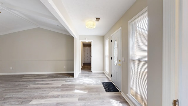 foyer with vaulted ceiling and light hardwood / wood-style floors